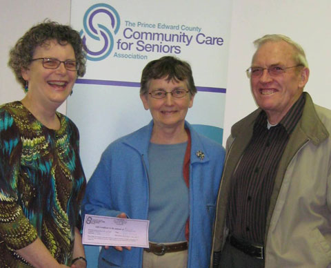 L-R Debbie MacDonald Moynes from Prince Edward Community Care presents contest winners Carrolle and Ken Wright from Consecon with gift certificates to the Seniors Luncheon Social for having submitted the new name chosen for the program.